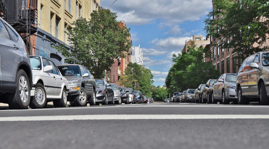 Bild på en gata där bilar står parkerade perfekt längst trottoarkanterna.