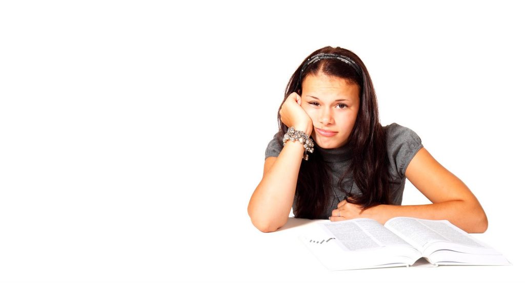 En tjej som pluggar och ser uppgiven ut.