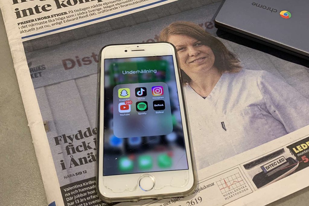 En mobiltelefon och en tidning.